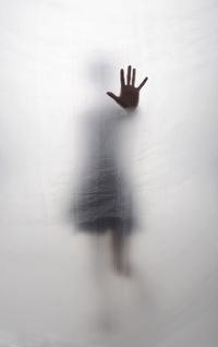 Young woman standing behind foil