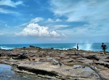 Scenic view of rocks on beach against sky