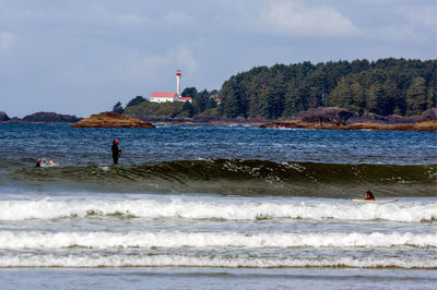 People on beach by sea against sky