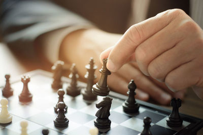 Close-up of hand holding chess pieces
