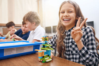 Portrait of happy friends sitting on table