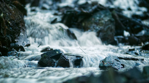 Close-up of water flowing over rocks in winter