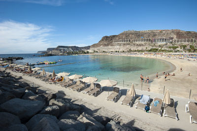 Panoramic view of people on beach against sky