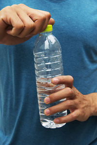 Midsection of man holding water bottle