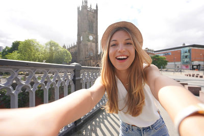 Smiling young woman takes self portrait in manchester, england, united kingdom