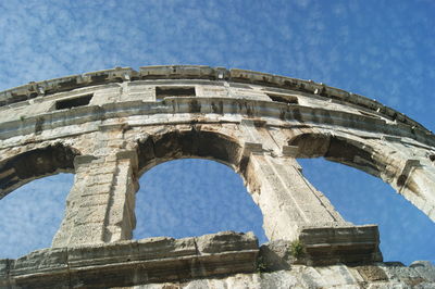 Low angle view of old ruin against blue sky