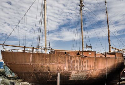 Sailboats moored in sea against sky