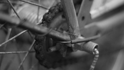 Close-up of rusty chain and bicycle on fence