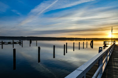 Pier on sea against sky during sunset