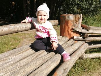 Portrait of cute baby girl sitting on bench