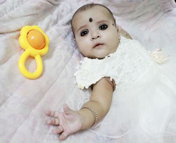 High angle view of baby lying on bed