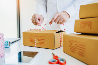 Woman packing cardboard boxes at desk in office