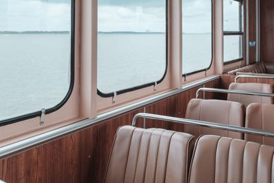 Empty seats in calm sea seen through window