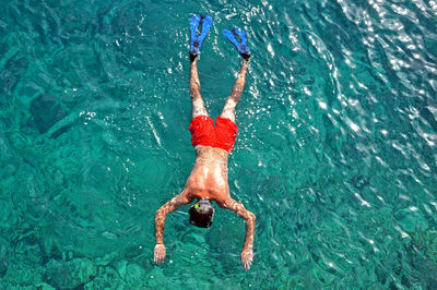 Directly above shot of shirtless man swimming in sea