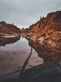 Surface level of rocks in water against sky