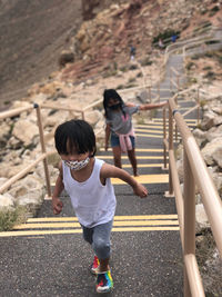 Full length of boy and girl on staircase