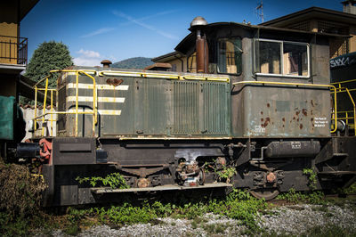 Abandoned train on railroad tracks against sky