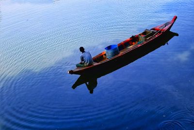 High angle view of men sitting on boat in sea