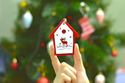 Close-up of hand holding christmas tree and toy