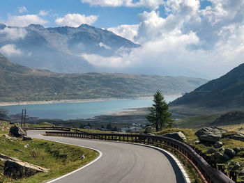 Road leading towards mountains against sky