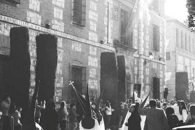 People on street amidst buildings in city