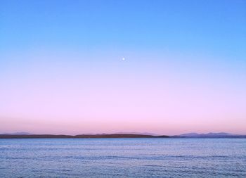 Scenic view of sea against clear sky at night