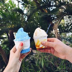 Cropped image of hands holding ice cream in containers
