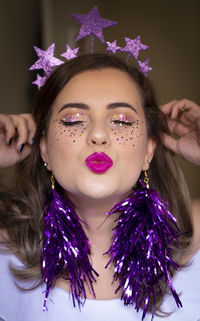 Close-up of woman with make-up on face puckering lips