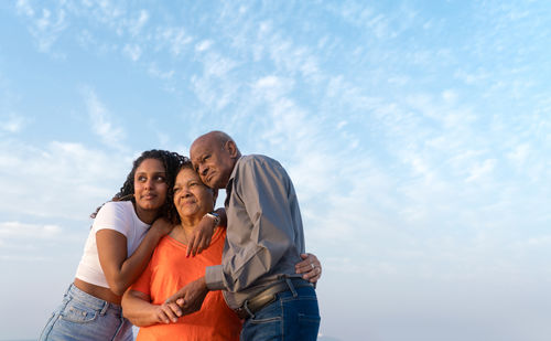 Senior couple with their granddaughter walking at the beach together