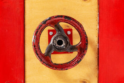 Close-up of door knocker on red wall