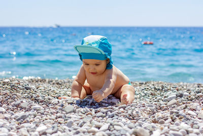 Full length of boy on pebbles at beach