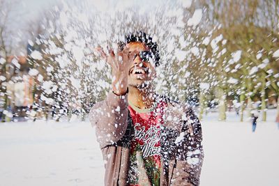 Portrait of smiling man standing in snow