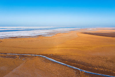 Scenic view of beach against blue sky