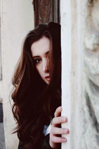 Portrait of woman peeking through window