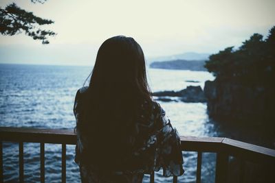 Rear view of woman looking at sea against sky
