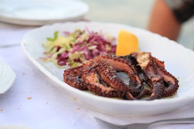 Close-up of meal with octopus and salad served in plate