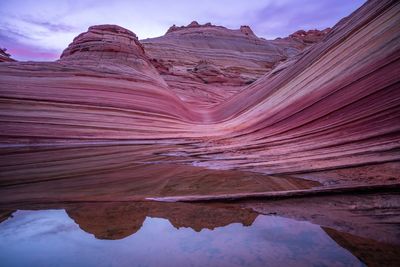 Scenic view of rock formations against cloudy sky
