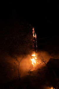 Low angle view of electricity pylon against sky at night