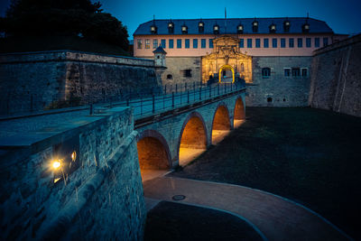 Arch bridge in city at night