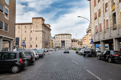 Cars on street amidst buildings in city