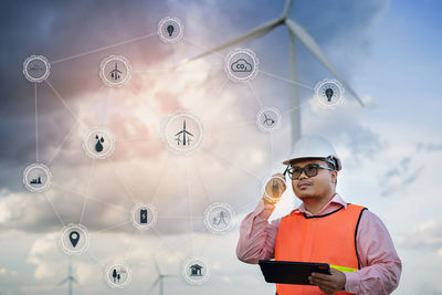 Man looking at camera while standing on mobile phone