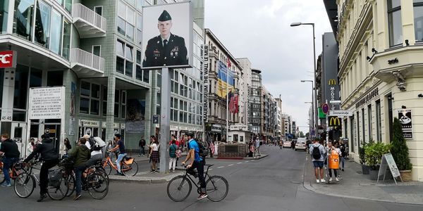 People on street against buildings in city