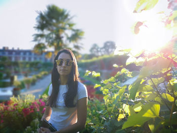 Portrait of smiling young woman against plants