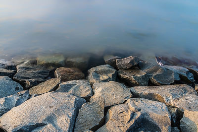 Close-up of rocks on shore against sky