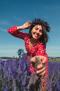 Portrait of young woman standing against sky