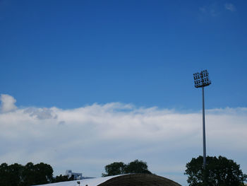 Low angle view of floodlight against blue sky