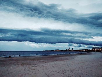 Scenic view of beach against dramatic sky