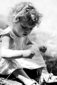 Close-up of girl sitting on field