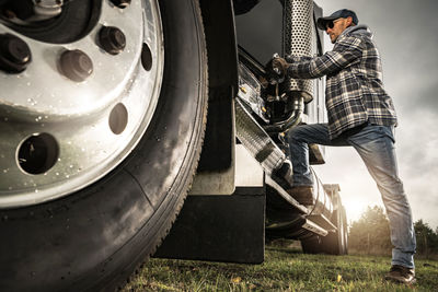 Low section of man repairing car