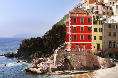 Scenic view of sea by buildings against sky